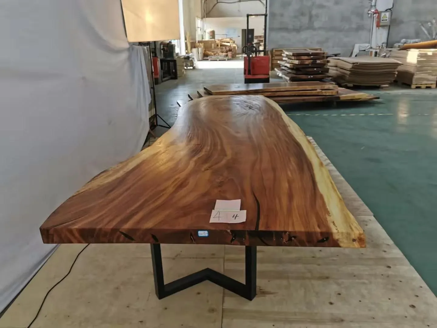 Table en bois massif à chant naturel sur piètement en acier, à l'atelier