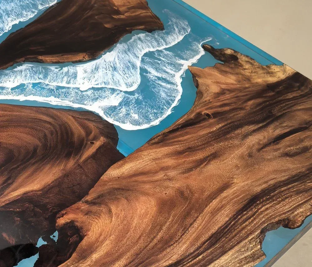 Résine bleue travaillée en vagues blanches contre un plateau en bois massif